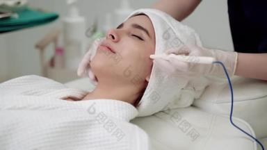 美容院，美女正在治疗她的脸。临床医生或护士使用美容诊所面部处理皮肤的工具加工.医生进行面部整容.